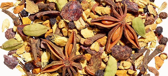 Chai Zutaten als Haufen, darunter Sternanis, Kardamom, Nelken